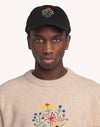 Model trägt die schwarze OLOW Blossom Yourself Cap mit farbiger Blumenstickerei – Vorderansicht