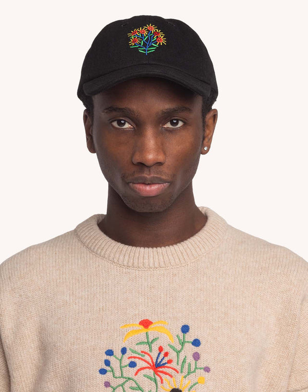 Model trägt die schwarze OLOW Blossom Yourself Cap mit farbiger Blumenstickerei – Vorderansicht